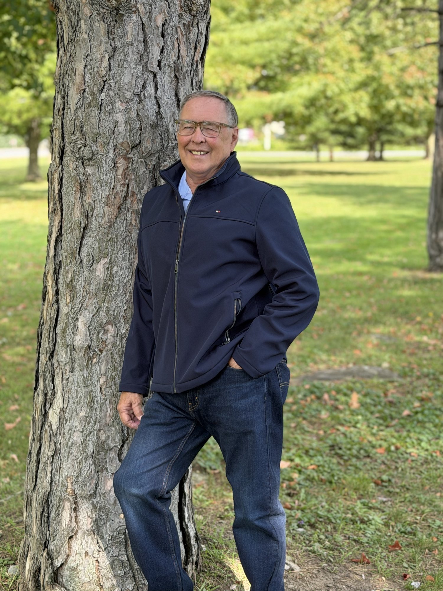 Keith MacCuaig standing outdoors beside a tree